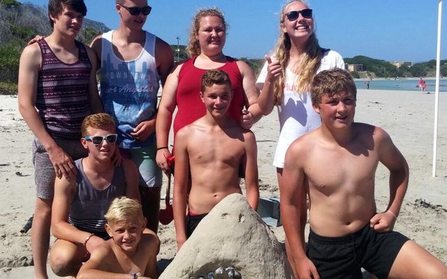 Die wenspan van die Sandkasteelkompetisie met hulle kop van â€˜n Grootwithaai, wat deur die Stranddiensspan gereÃ«l is  